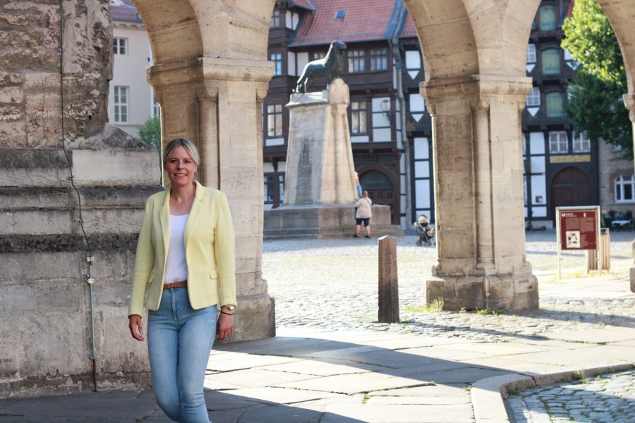 Julia Retzlaff geht unter dem Durchgang zwischen Dom und Burg Dankwarderode in Richtung Münzstraße. Im Hintergrund ist der Burglöwe zu sehen.