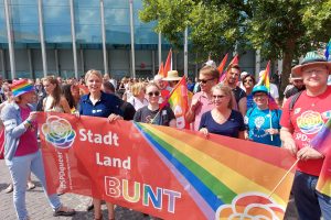 SPD-Landtagskandidierende Julia Retzlaff, Annette Schütze und Christoph Bratmann sowie weitere SPD-Mitglieder tragen ein Banner mit Aufdruck "Stadt Land Bunt" auf der CSD-Parade