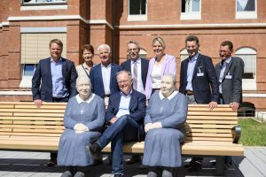 Ministerpräsident Stephan Weil hat zwischen den beiden Diakonissinnen-Figuren Platz auf der Bank vor dem Neubau des Marienstifts genommen. Dahinter stehen Ingo Beese, Hans-Heinrich Seeliger, Jörg Kittner und Rosemarie Oelschläger, alle Evangelische Stiftung Neuerkerode. Ebenfalls dabei Julia Rtezlaff und Christoph Bratmann MdL.
