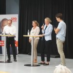 Auf der Bühne stehen hinter Stehtischen fünf Personen: Christoph Bratmann, Grant-Hendrik Tonne, Annette Schütze, Julia Retzlaff und ein Moderator, ein Schüler vom Landesschüler:innenrat.