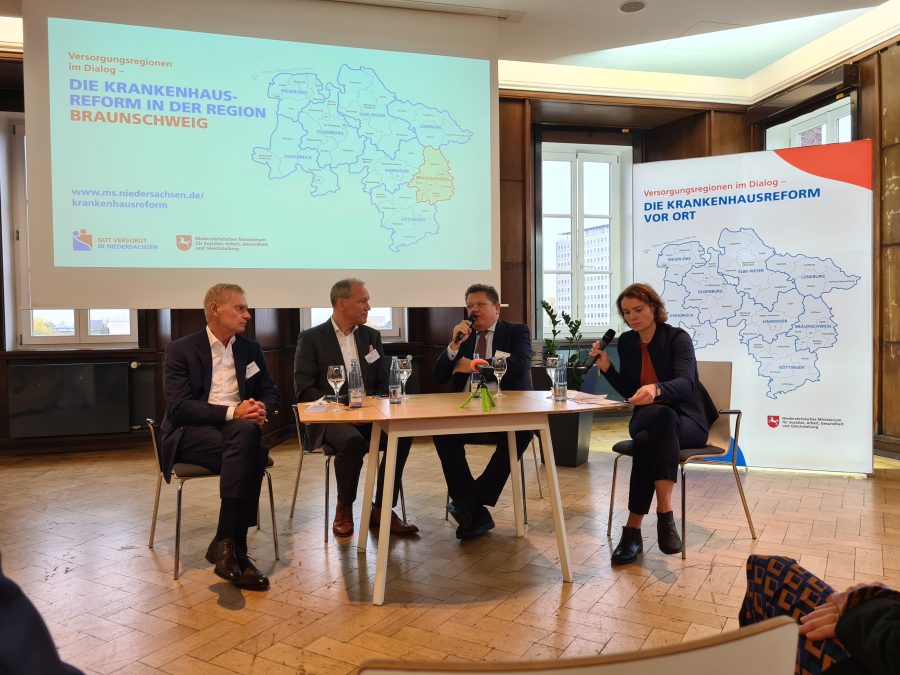 Vertreter der AOK Niedersachsen, der Niedersächischen Krankenhausgesellschaft, Minister Philippi und Moderatorin Lea Karrasch auf dem Podium Der Dialog-Veranstaltung.