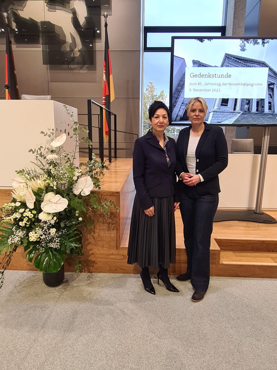 Immacolata Glosemeyer, MdL aus Wolfsburg und Julia Retzlaff, MdL im Plenarsaal des Niedersächsischen Landtages vor Blumenschmuck anlässlich des Gedenktages